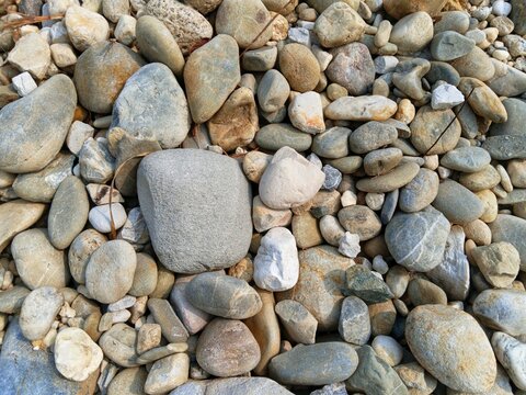 Premium grey river gravel pattern for contemporary landscape architecture, minimalist walkway paving material, indoor fountain flooring, organic stone background detail, top view closeup of smooth rou