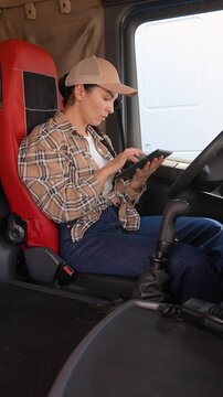 Female truck driver using digital tablet in cabin