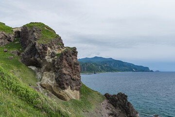 日本　北海道積丹町・神威岬の荒々しくそびえ立つ岩肌と奥に広がる日本海 © pespiero