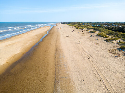 Drone shot looking along Mablethorpe beach in Lincolnshire, UK, a sandy beach beneath a blue sky