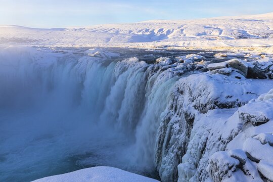 Godafoss waterfall in first morning sun, snow-covered landscape, Northern Iceland Eyestra, Iceland