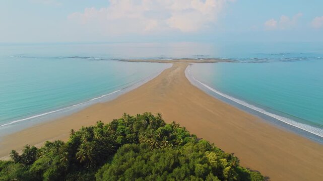 Distant aerial view of rocky reef and Whale Tail sandbar in the sea at Marino Ballena National Park Costa Rica