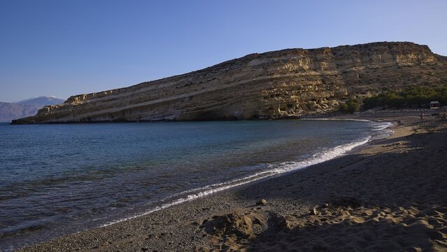 Neolithic caves, former hippie paradise, secluded beach with gentle waves and impressive rocks in the background, Matala, south coast, Crete, Greek Islands, Greece