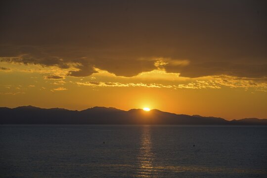 Sunset over the island of Corsica on, Capo Sant Andrea, Marciana, Province of Livorno, Italy