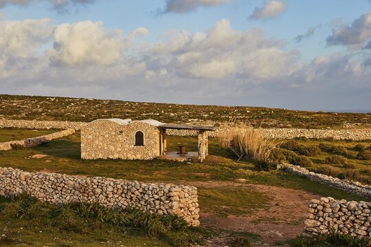 Late afternoon light, sten walls, Dammuso, tourist accommodation, barren landscape, Lampedusa Island, Agrigento Province, Pelagic Islands, Sicily, Italy