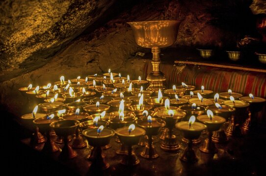 Cave with candles and Buddha images along the Kailash Kora, Western Tibet, Asia;