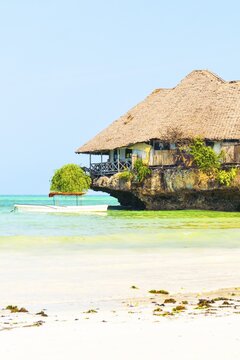 Unique wooden restaurant structure built on coral rock outcrop in turquoise Indian Ocean waters near Michamvi Pingwe beach Zanzibar Tanzania