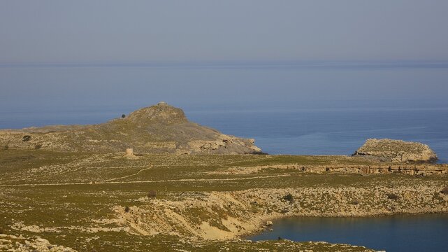 Tranquil coastal landscape with a lighthouse on a hill, Lindos, Rhodes, Dodecanese, Greek Islands, Greece