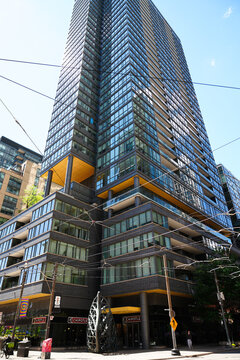 Toronto, Canada - June 23, 2026: Modern glass condominium skyscraper with Chipotle restaurant at street level