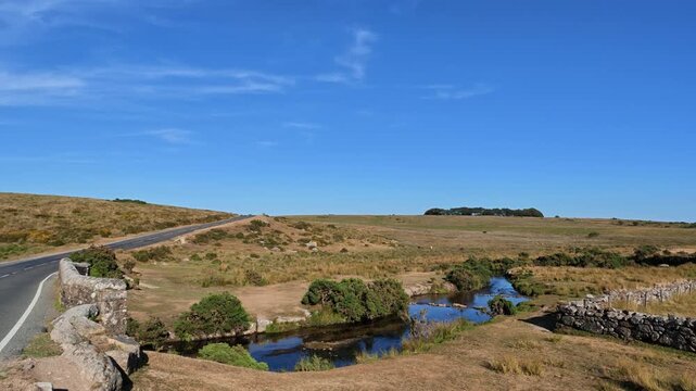 Dartmoor Devon England UK. 13.08.2026. Video. A tranquil rural scene on Dartmoor unfolds with a clear blue sky above the west River Dart and a rustic stone boundary wall