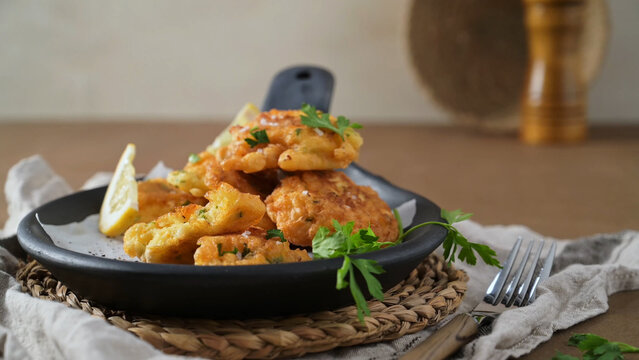 Homemade cod fish fritters served in a black skillet