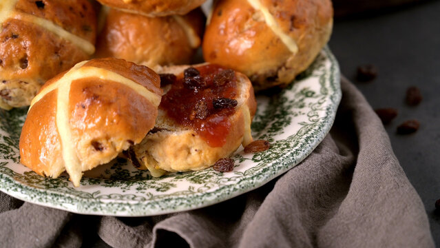 Fresh Homemade Hot Cross Buns with Jam and Sultanas on a Vintage Plate