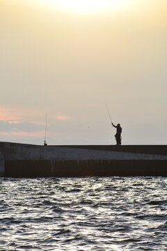 釣り人　堤防　海　シルエット　余白　ネガティブスペース　釣り竿