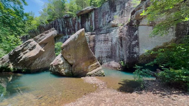 The famous Devil's Backbone sandstone formation resting in a clear creek pool surrounded by lush forest at Bell Smith Springs in Shawnee National Forest.