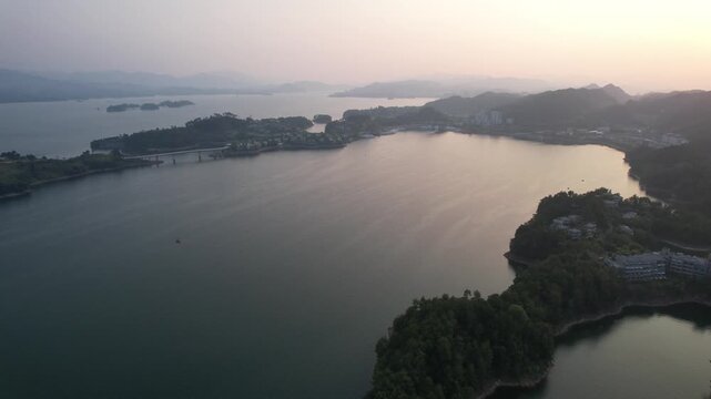 Forested lake islands beneath a soft sunset in Qiandao Lake China