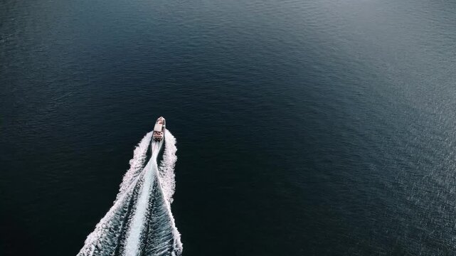 Boat in dark water. Isolated individual commands speedy boat across profound dark waters with quiet intensity