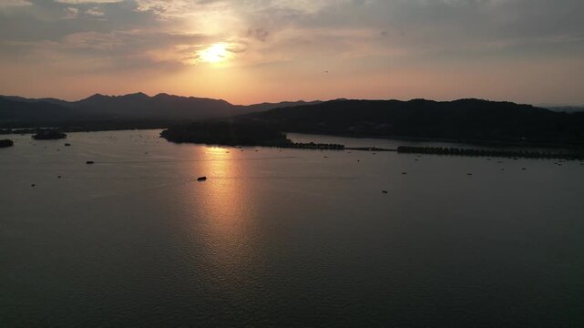 West Lake islands and boats beneath sunset in Hangzhou China
