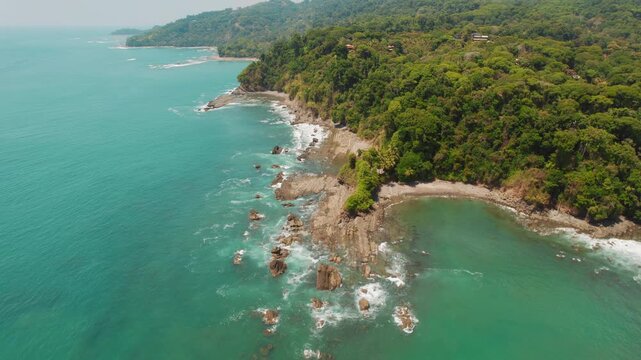Aerial view of coastline with cliffs and turquoise ocean in sunlight Costa Rica