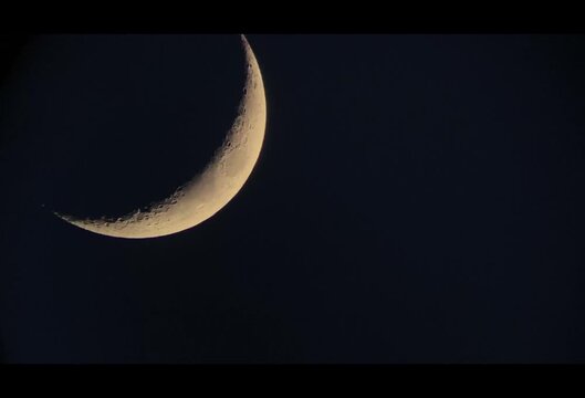 A high-resolution image of the waxing crescent moon. Details of lunar craters and the lunar terminator are beautifully illuminated by sunlight amidst the darkness of space.