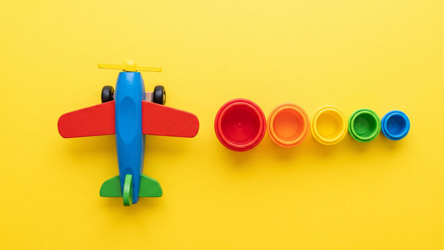 Colorful Toy Airplane and Miniature Toys Arranged on a Bright Yellow Background