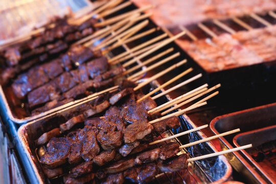 Wagyu beef skewers grilling on hot teppanyaki teppan iron plate, premium Japanese marbled meat on wooden sticks, traditional street food festival, Tokyo, Japan, market with local vendor stalls cooking