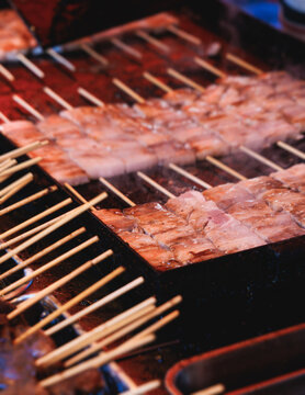 Wagyu beef skewers grilling on hot teppanyaki teppan iron plate, premium Japanese marbled meat on wooden sticks, traditional street food festival, Tokyo, Japan, market with local vendor stalls cooking