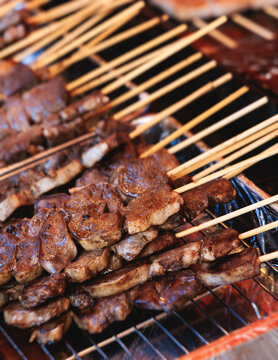 Wagyu beef skewers grilling on hot teppanyaki teppan iron plate, premium Japanese marbled meat on wooden sticks, traditional street food festival, Tokyo, Japan, market with local vendor stalls cooking