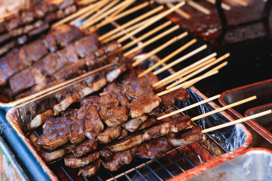 Wagyu beef skewers grilling on hot teppanyaki teppan iron plate, premium Japanese marbled meat on wooden sticks, traditional street food festival, Tokyo, Japan, market with local vendor stalls cooking