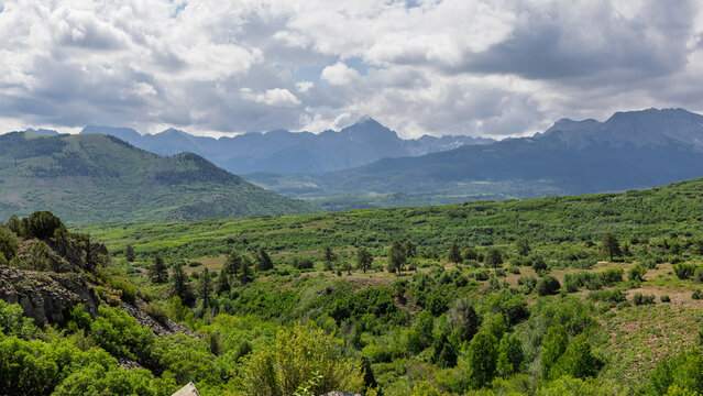 San Juan mountains landscape with green valley and cloudy sky