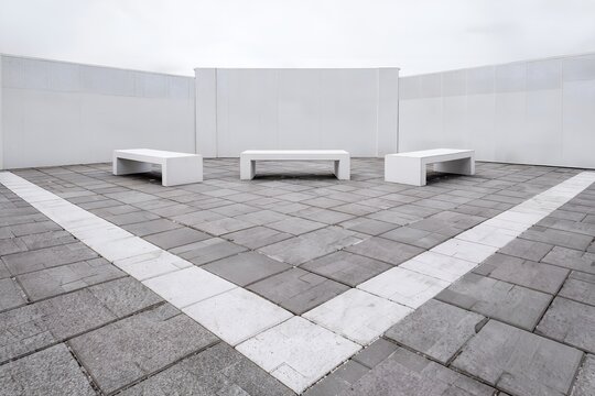 Quiet Empty School Courtyard with White Concrete Benches and White Walls