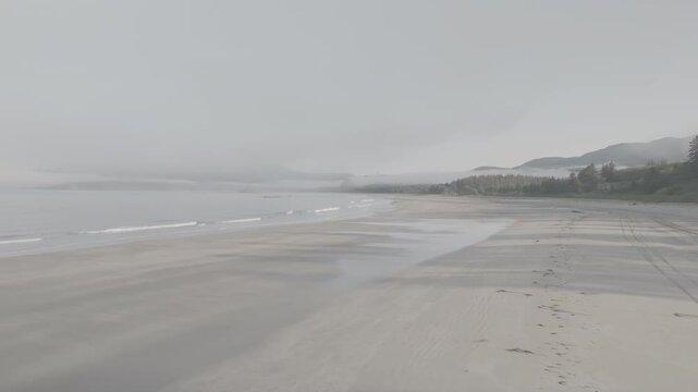 Aerial view flying along sandy beach with ocean waves and fog off Washington coast, ocean waves of Olympic Peninsula (D-log / Ungraded version)