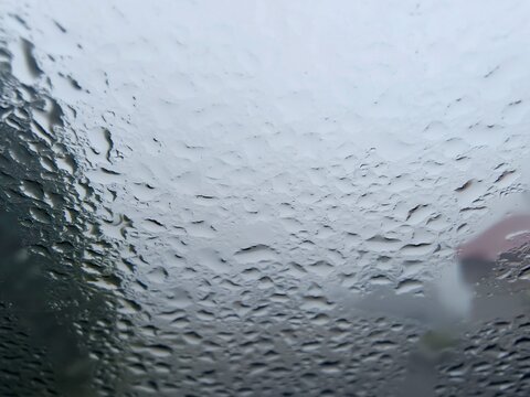 Abstract texture background of water drops and condensation on glass car window pane.