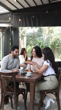 group of latin friends talking and having fun in a coffeeshop in Mexico Latin America, hispanic people holding a coffee cup