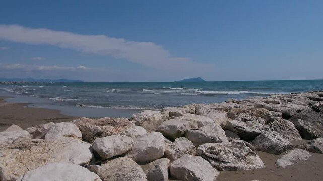 Scenic view of Foce Verde beach and breakwater rocks during spring in Marina di Latina, Italy