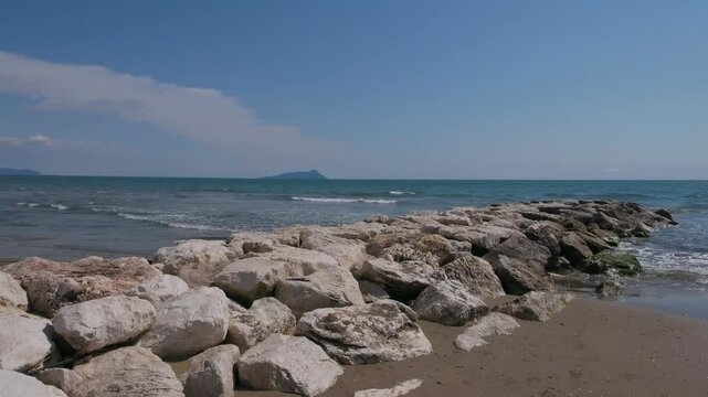 Scenic view of Foce Verde beach and breakwater rocks during spring in Marina di Latina, Italy