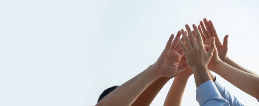 Group of hands reaching towards a clear sky symbolizing hope and unity