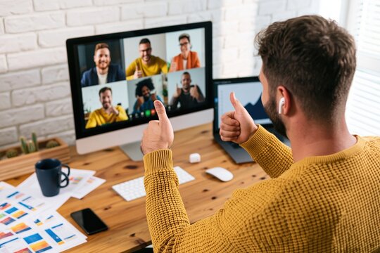 Remote man in yellow sweater on video conference call working from home business