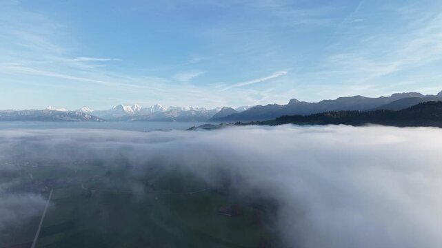 Swiss alps and countyside over the mist at blue sky. Shot on DJI Mavic Air 3s 4K 60fps 150mbit.