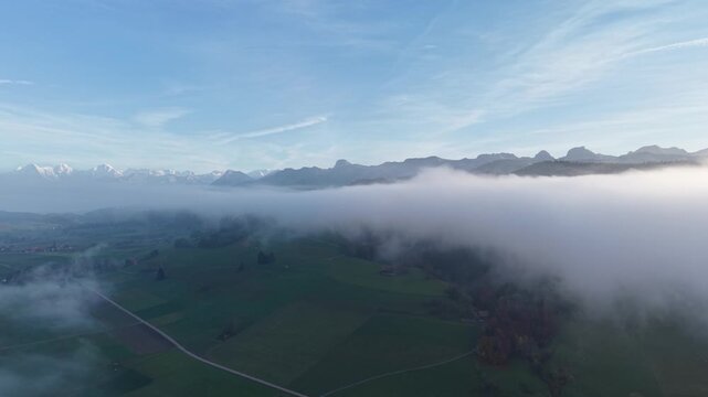 Swiss alps and countyside over the mist at blue sky. Shot on DJI Mavic Air 3s 4K 60fps 150mbit.