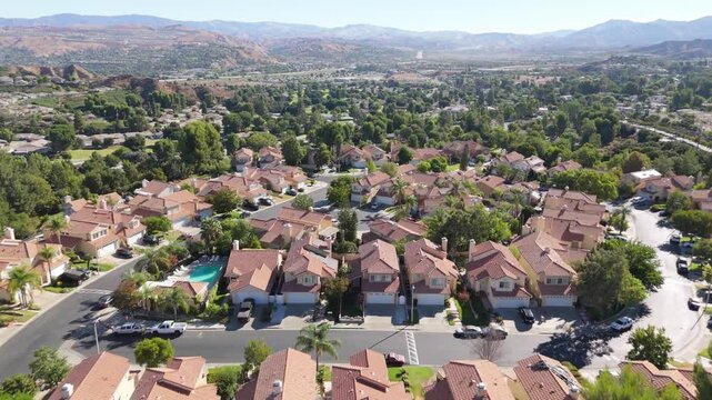 Santa Clarita Valley residential neighborhood in California with a planned community built in a suburban grid layout - drone flyover on a sunny day