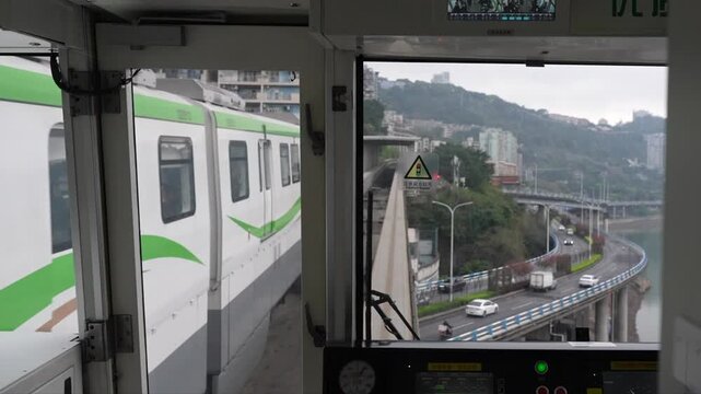 Monorail POV riding on an elevated track and passing another monorail in Chongqing China during a cloudy day.