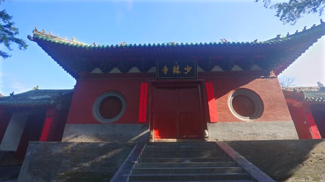 Ancient buildings of Shaolin Monastery with flying pigeons at sunrise, sacred landmark of Chinese martial arts culture