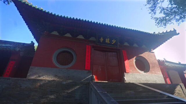 Ancient buildings of Shaolin Monastery with flying pigeons at sunrise, sacred landmark of Chinese martial arts culture