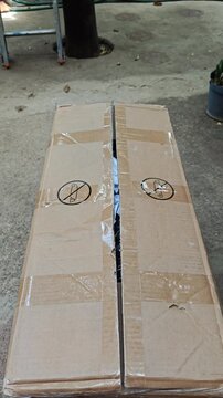 Close up of Hands Opening Cardboard Box Sealed with Adhesive Packaging Tape