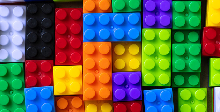 Colorful plastic building blocks background, top view macro shoot of vibrant toy bricks pattern for education and creativity concept.