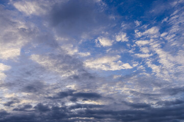 Fototapeta premium Beautiful Blue Sky with Fluffy White and Grey Clouds,A scenic view of a bright blue sky filled with a dynamic mix of fluffy white and soft grey clouds, perfect for nature and background concepts.