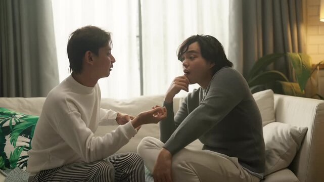 couple having intense heated argument on living room sofa, tense body language and raised voices, relationship conflict and emotional distress concept, dramatic indoor lighting.