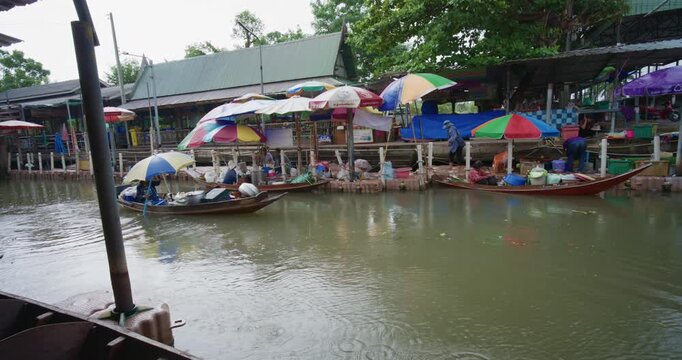 Crowded wooden boats in canal with fruits, vegetables, foods and grocery products for sell and trade by villagers at Tha Kha traditional floating market Samut Sogkhram, Thailand