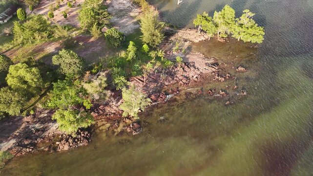 Aerial View of Rocky Coastline and Lush Green Trees in Batam, Indonesia. 4K