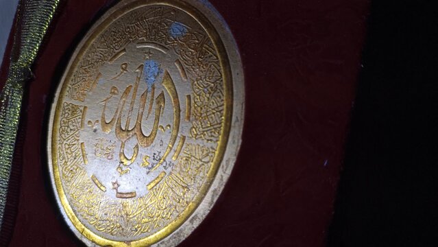 Red Yasin book with a golden Arabic inscription of Allah on the cover